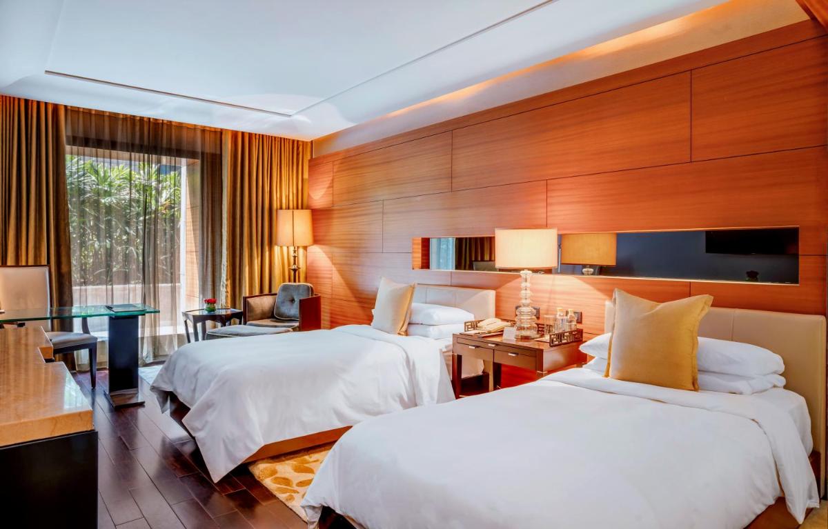 a hotel room with two beds and a television at The Leela Ambience Gurugram Hotel & Residences - The Luxury Urban Sanctuary in Gurgaon