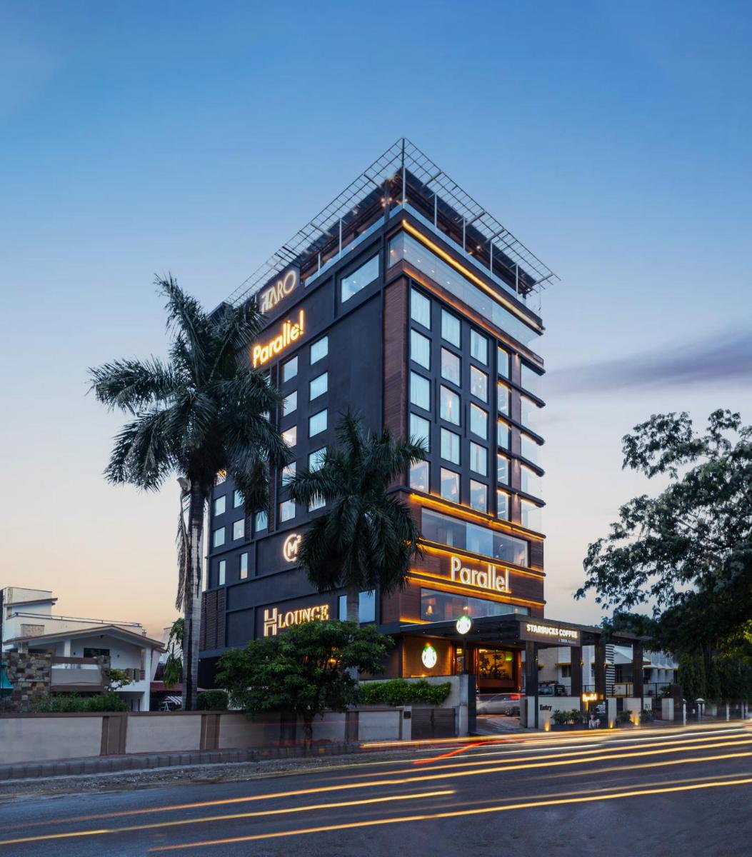 a hotel building with a palm tree in front of it at Parallel Hotel Udaipur, a member of Radisson Individuals in Udaipur