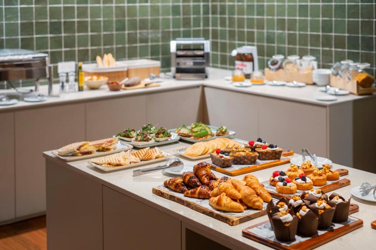 Una línea de buffet con muchos tipos diferentes de comida. en Hotel TorreMirona Golf & Spa, en Navata