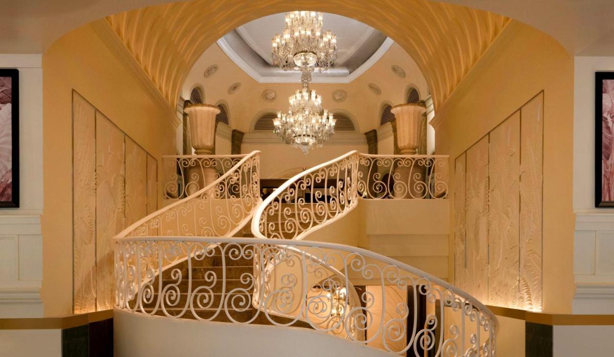 a spiral staircase in a building with a chandelier at Hilton Mumbai International Airport Hotel in Mumbai
