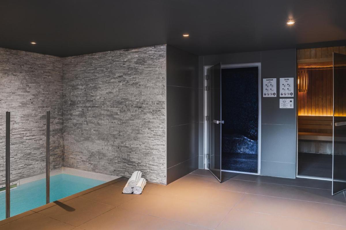 Cette chambre dispose d'une piscine et d'un mur en briques. dans l'établissement Heliopic Hotel & Spa, à Chamonix-Mont-Blanc