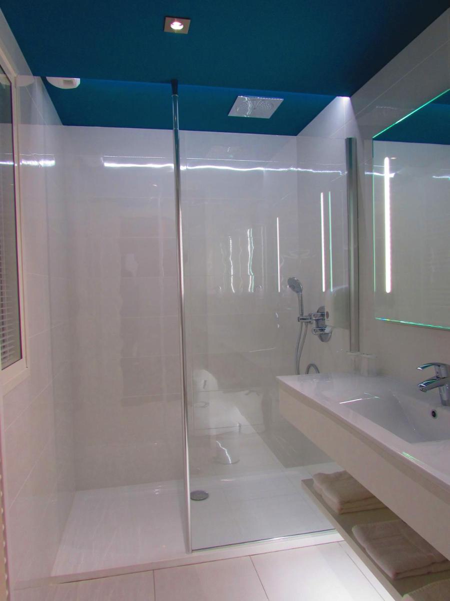 une salle de bain avec douche et lavabo dans l'établissement Brit Hotel & Spa Saint Brieuc Plérin, à Plérin