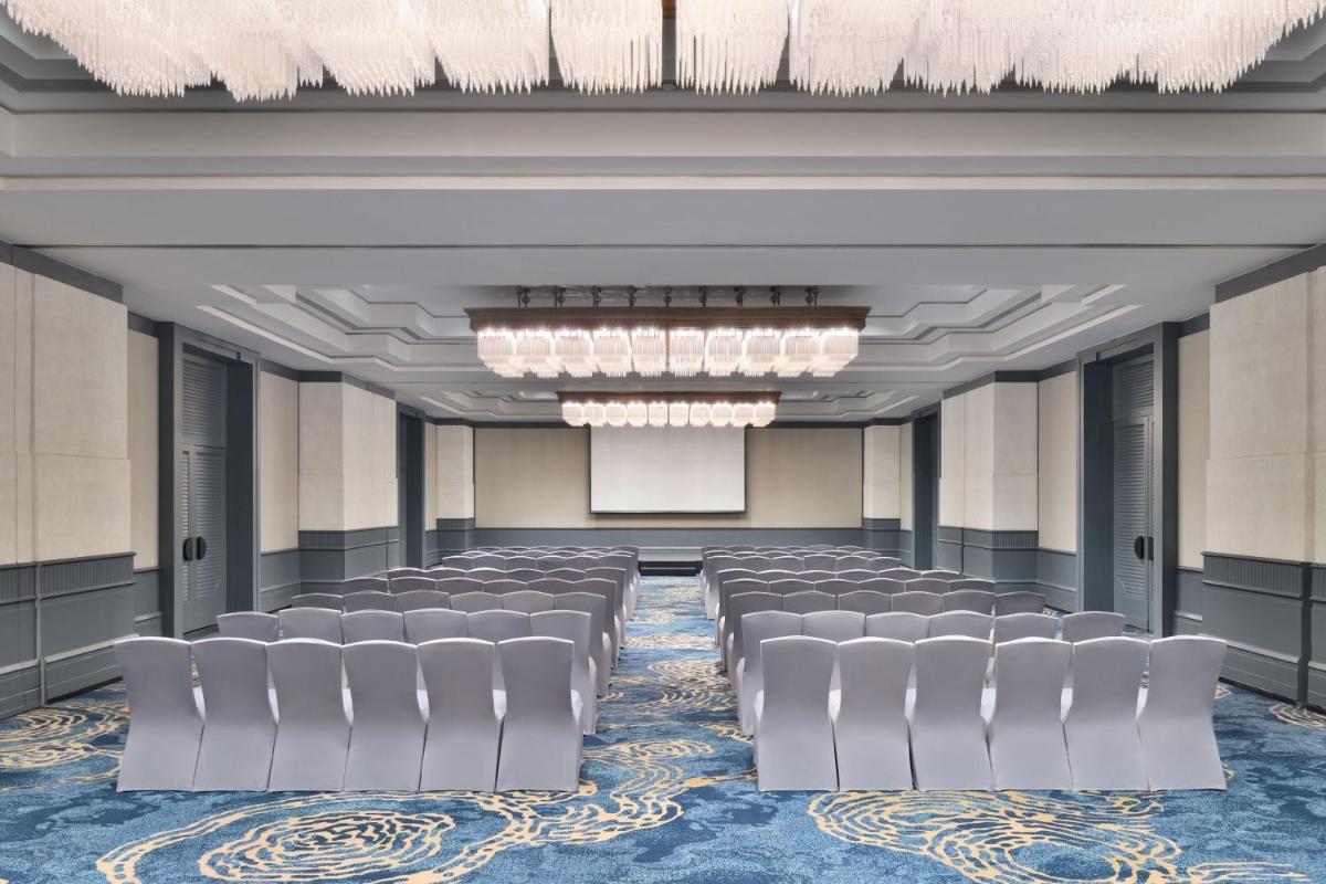 a conference room with chairs and a screen at The Westin Mumbai Powai Lake in Mumbai