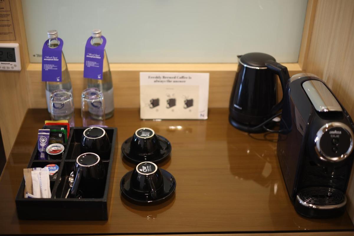 a table with a coffee maker and a toaster at Novotel Hyderabad Airport in Hyderabad