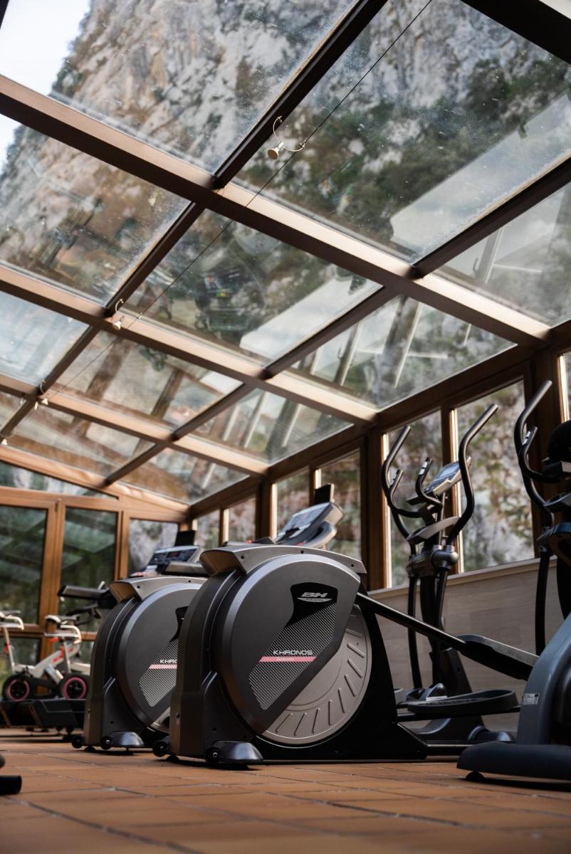 Un gimnasio con un montón de bicicletas estáticas en una habitación. en Hotel Balneario La Hermida, en La Hermida