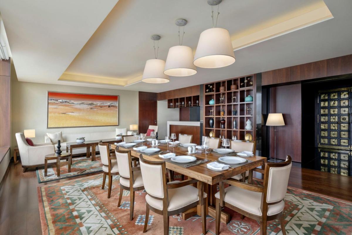 a dining room with a long table and chairs at JW Marriott Pune in Pune