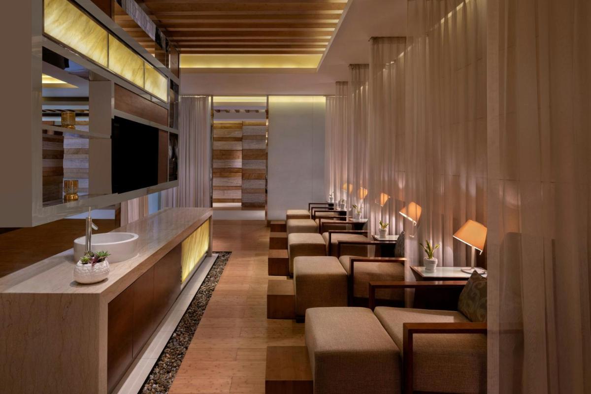 a waiting room with a row of tables and chairs at JW Marriott Pune in Pune