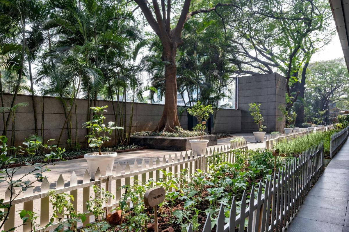 a white picket fence in a garden with plants at JW Marriott Pune in Pune