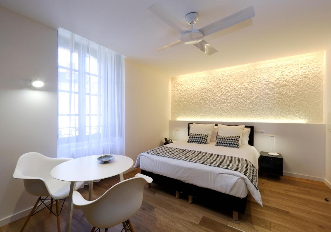 une chambre avec un lit, une table et des chaises dans l'établissement Les Maisons du Pont - Charme & Caractère, à Aubusson