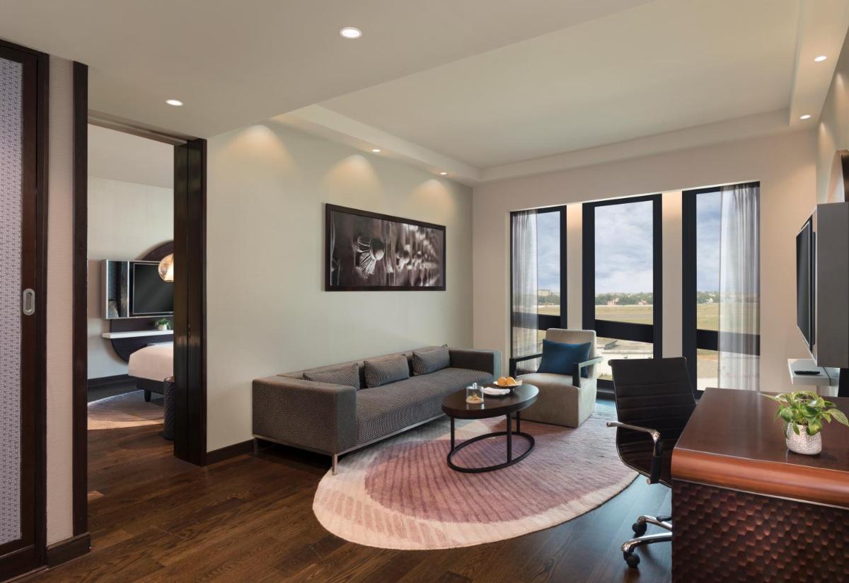 a living room with a couch and a table at Pullman New Delhi Aerocity in New Delhi a living room with a couch and a table at Pullman New Delhi Aerocity in New Delhi