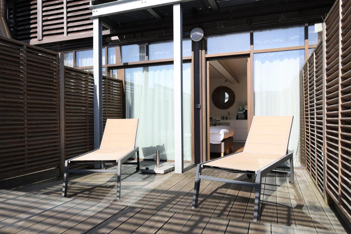 deux chaises et une table sur un balcon dans l'établissement Résidence Les Suites du Port - by Le Saint Ferdinand, à Arcachon