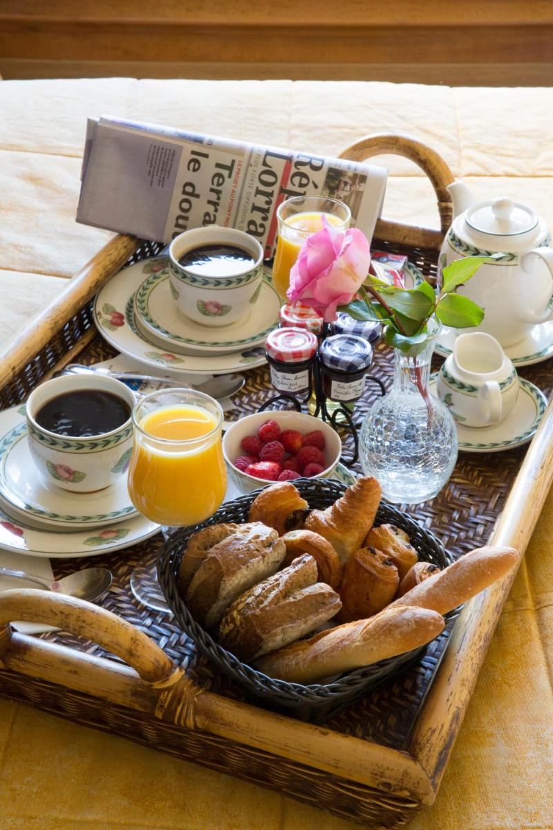 un plateau de nourriture avec du pain et des boissons sur une table dans l'établissement Hôtel du Domaine de La Grange de Condé, à Condé-Northen