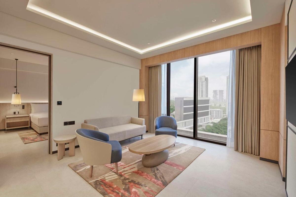 a living room with a couch and a table and chairs at Hilton Gurugram Baani City Centre in Gurgaon