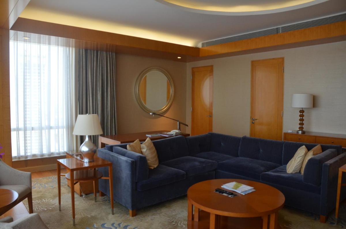 a living room with a blue couch and a table at Four Seasons Hotel Mumbai in Mumbai