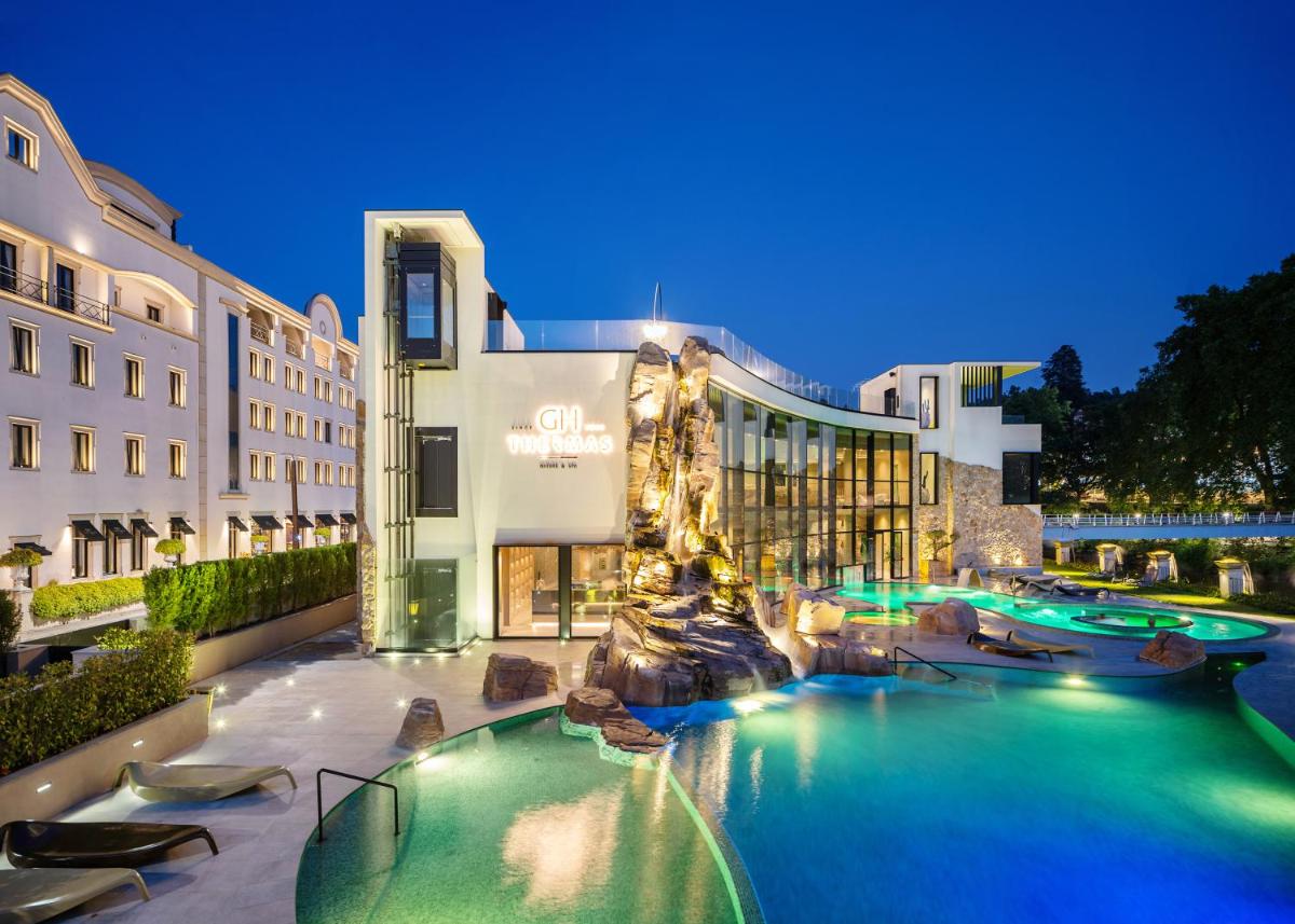 um hotel com piscina à noite em Grande Hotel Thermas Nature & SPA nas Termas de São Pedro do Sul