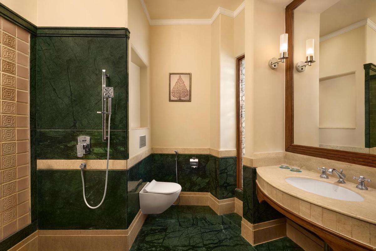a bathroom with a shower and a toilet and a sink at Le Meridien Jaipur Resort & Spa in Jaipur