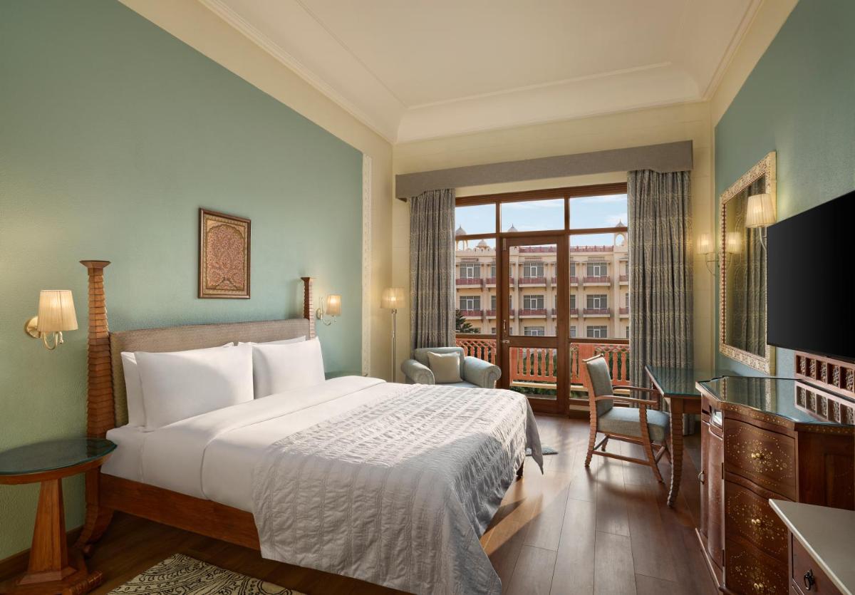 a hotel room with a bed and a balcony at Le Meridien Jaipur Resort & Spa in Jaipur