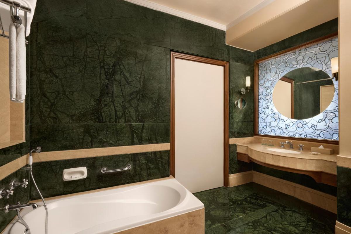 a bathroom with a tub and a sink at Le Meridien Jaipur Resort & Spa in Jaipur