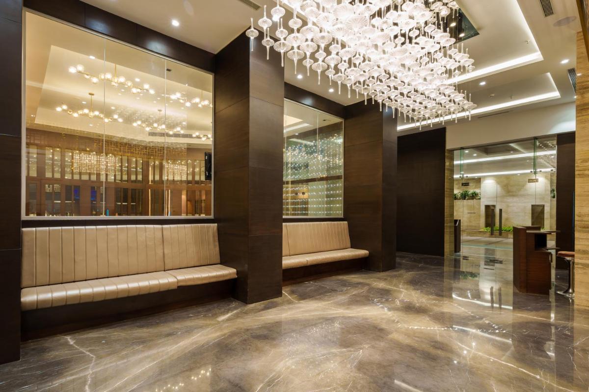 a lobby of a building with a chandelier at Pharos Hotels in Chennai