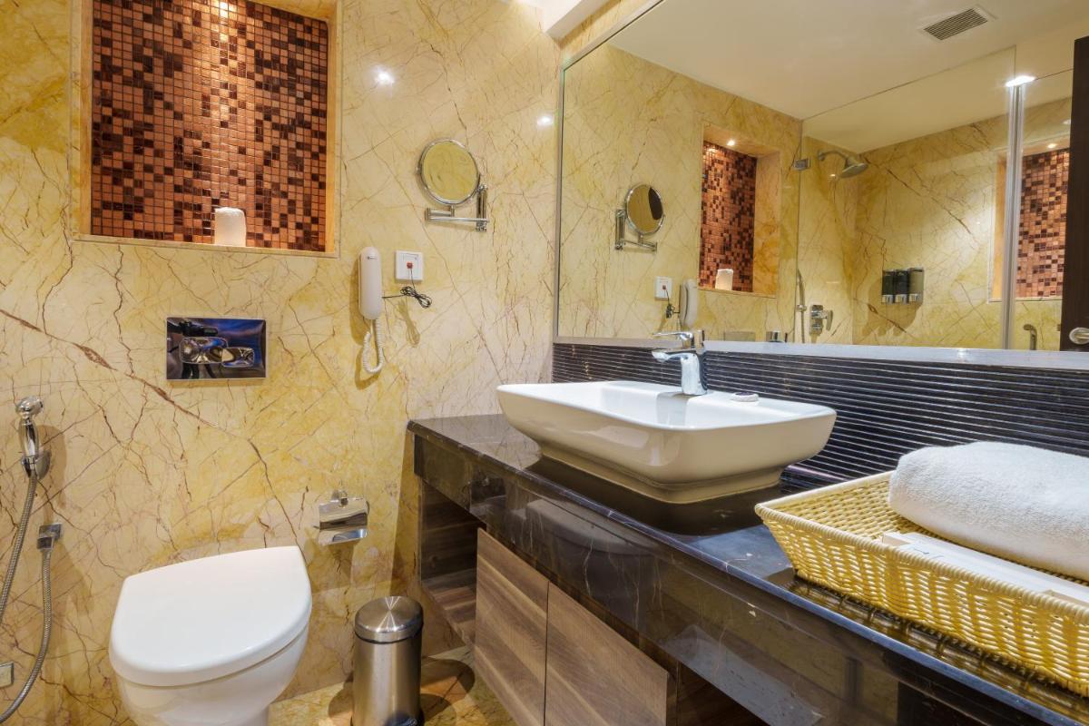 a bathroom with a sink and a toilet at Pharos Hotels in Chennai