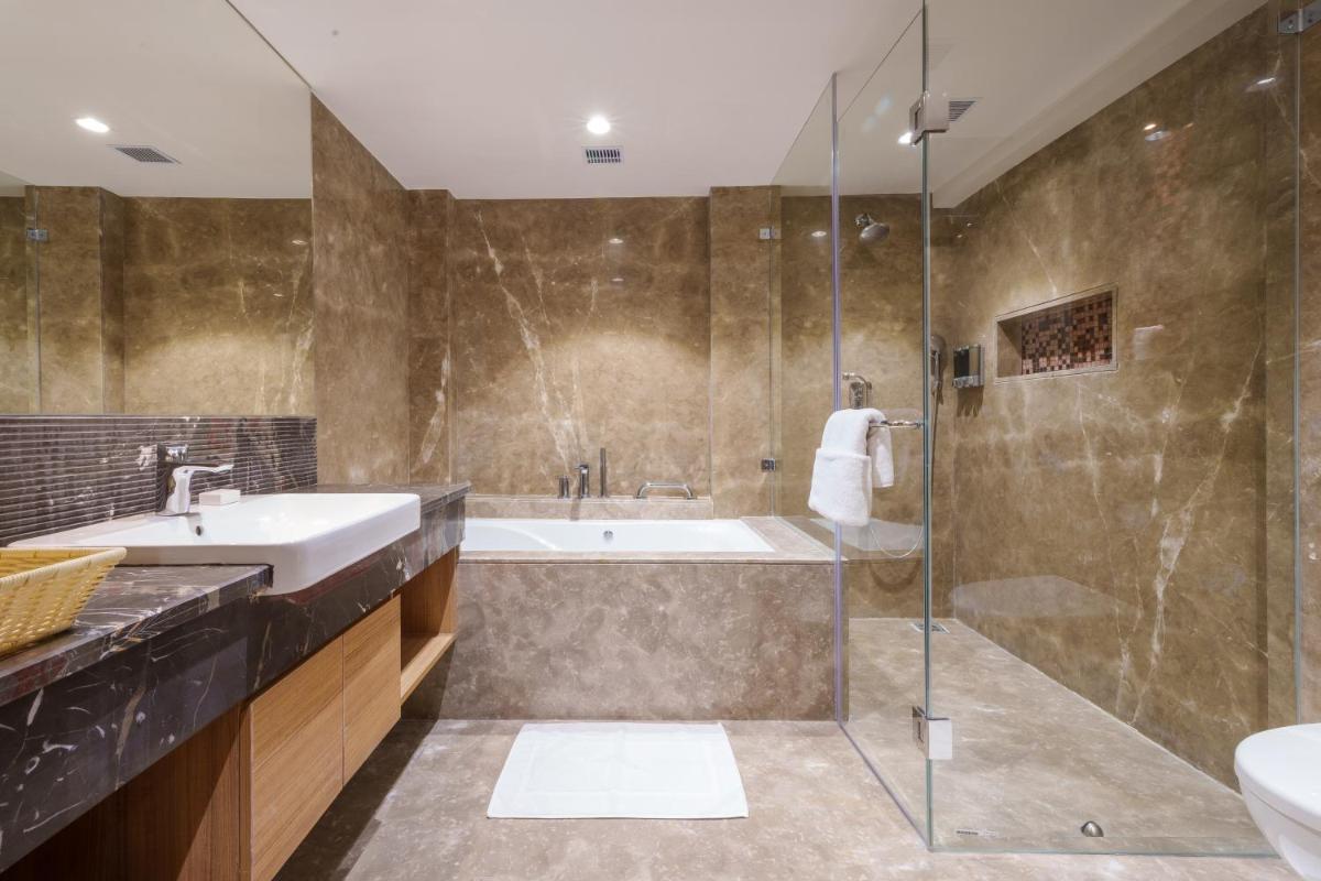 a bathroom with a tub and a sink and a shower at Pharos Hotels in Chennai