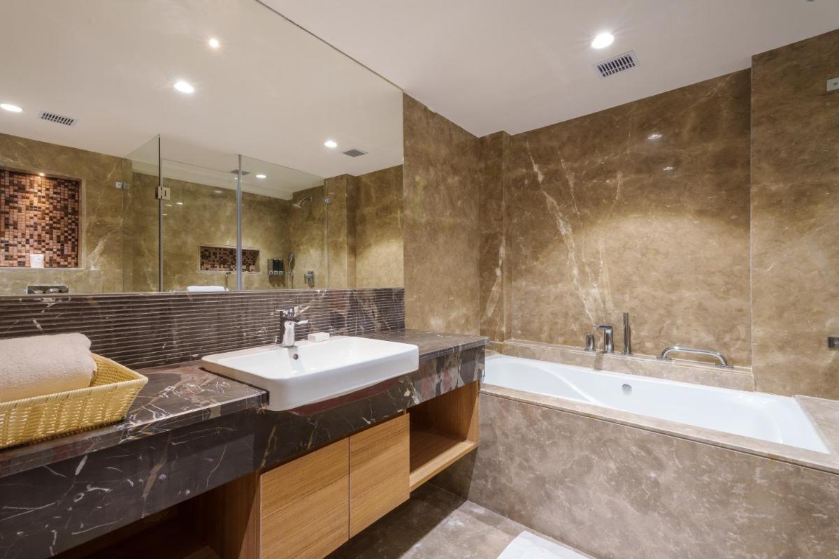 a bathroom with a sink and a bath tub at Pharos Hotels in Chennai