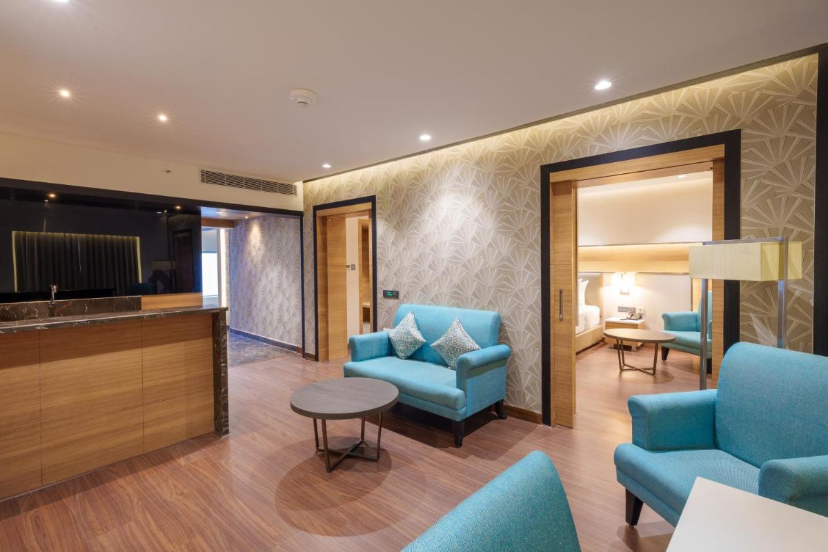 a hotel lobby with blue chairs and a table at Pharos Hotels in Chennai