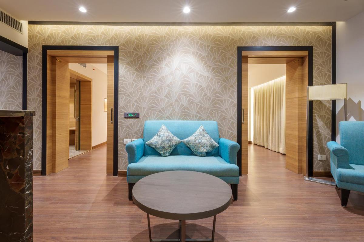 a lobby with two blue chairs and a table at Pharos Hotels in Chennai