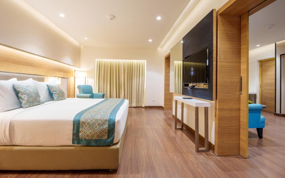a hotel room with a bed and a television at Pharos Hotels in Chennai