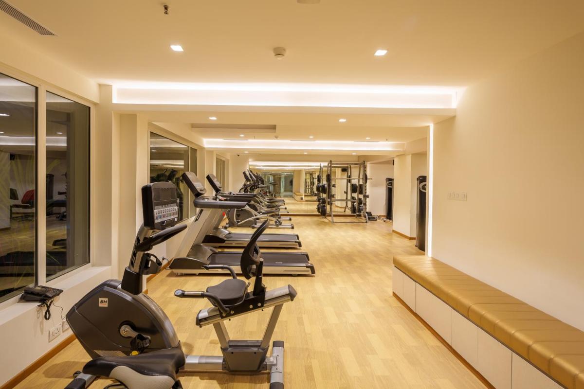 a row of exercise bikes in a gym at Pharos Hotels in Chennai