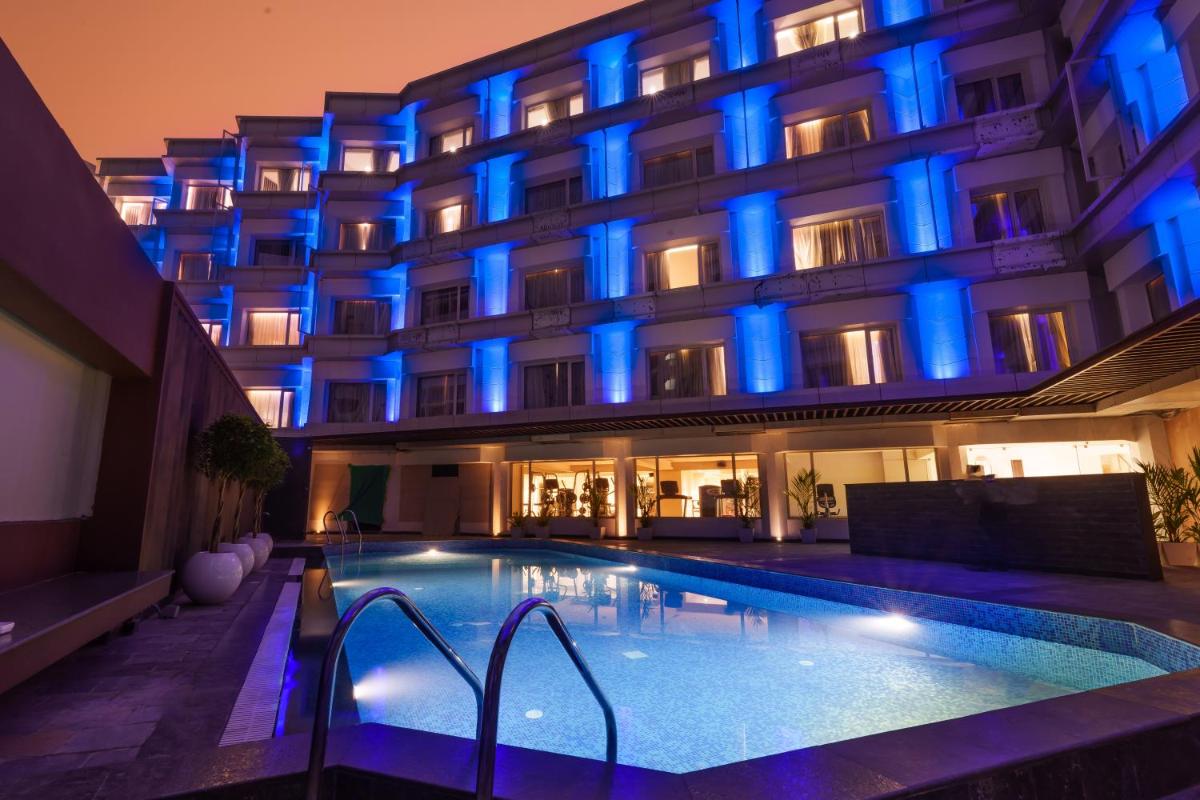 a hotel with a swimming pool in front of it at Pharos Hotels in Chennai