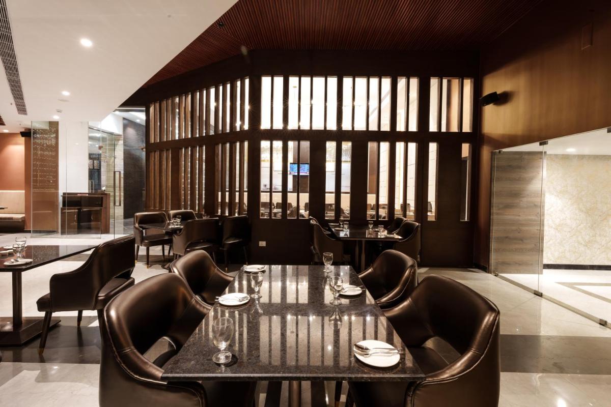 a dining room with a table and chairs at Pharos Hotels in Chennai