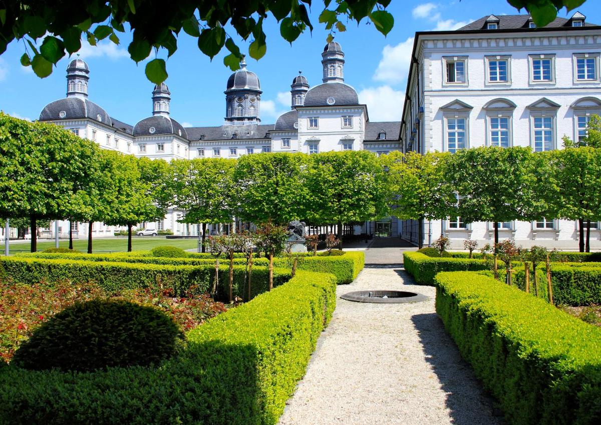 einen Garten vor einem großen Gebäude in der Unterkunft Althoff Grandhotel Schloss Bensberg in Bergisch Gladbach