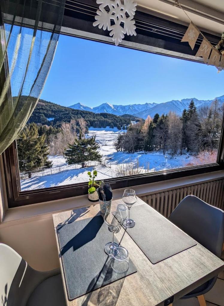 - une table avec des verres à vin devant une grande fenêtre dans l'établissement Hotel Corrieu, à La Llagonne