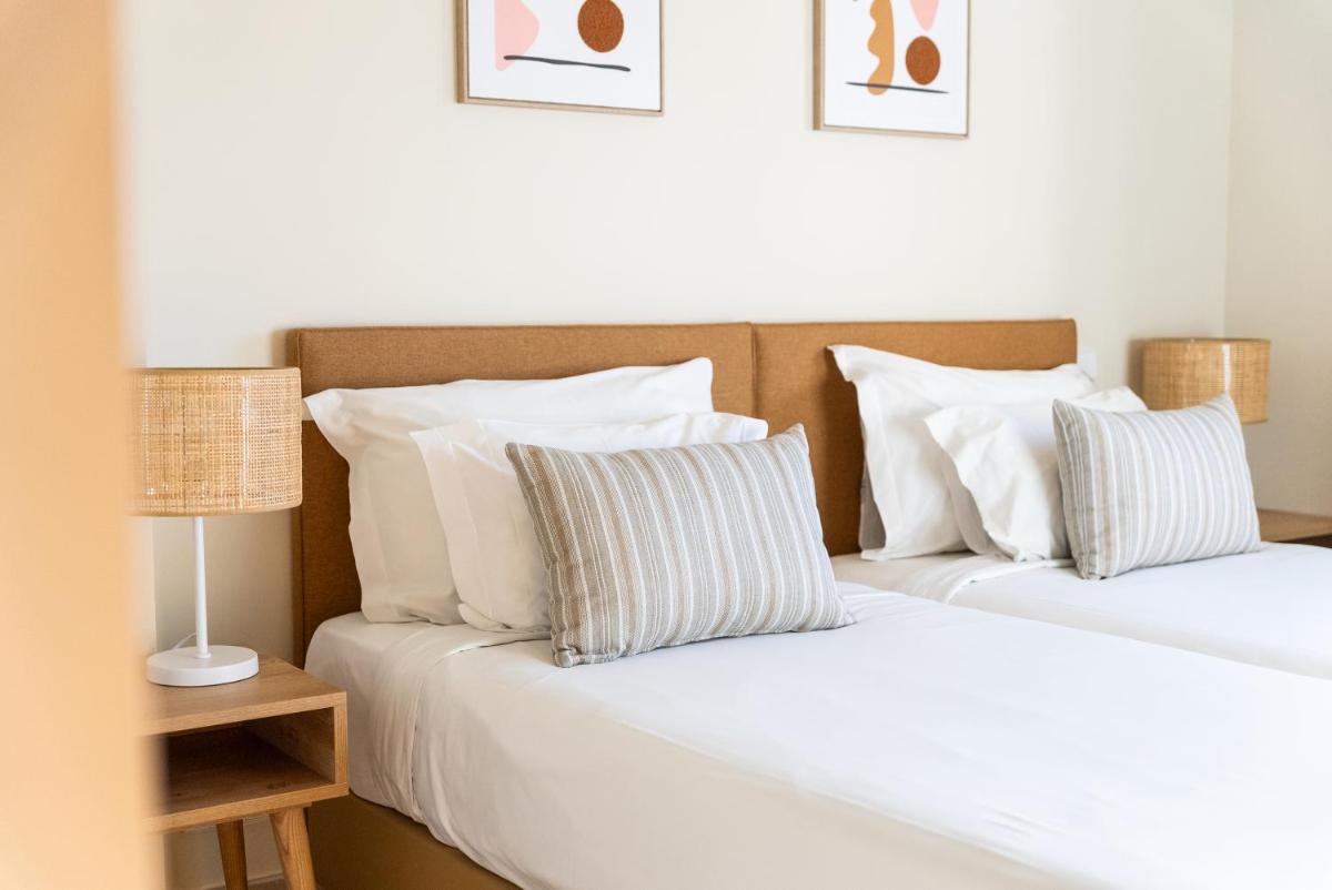 duas camas uma ao lado da outra em um quarto em Eden Villas & Apartments em Albufeira