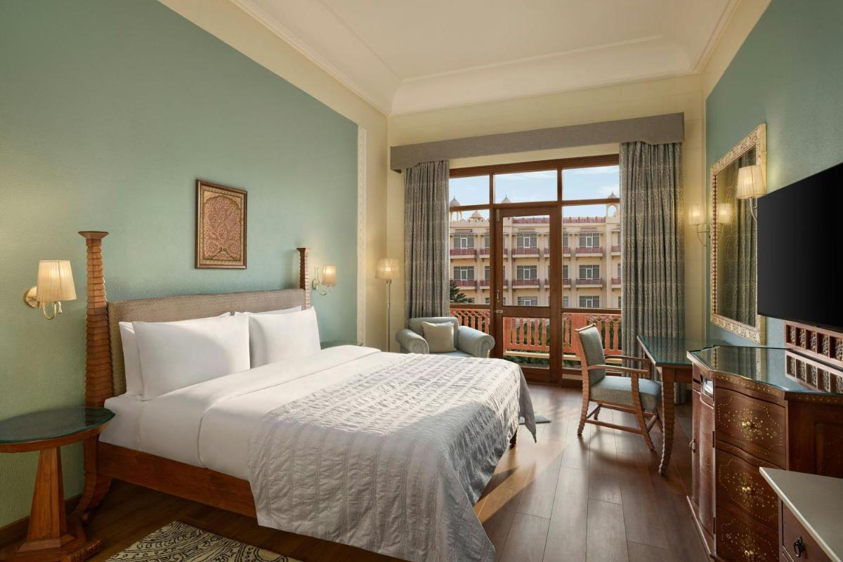 a hotel room with a bed and a balcony at Le Meridien Jaipur Resort & Spa in Jaipur