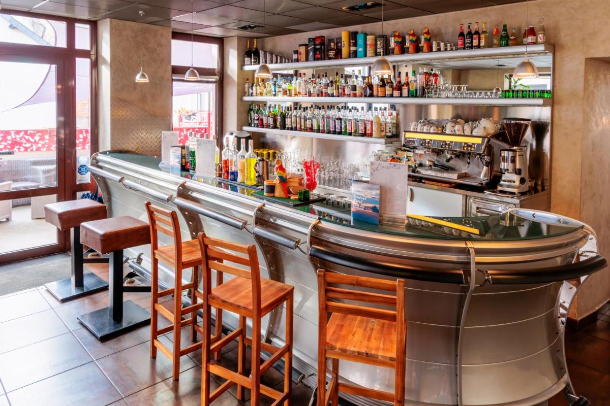 un bar avec des chaises et un comptoir dans un restaurant dans l'établissement Logis Central Hôtel - Restaurant & Spa, à Bort-les-Orgues