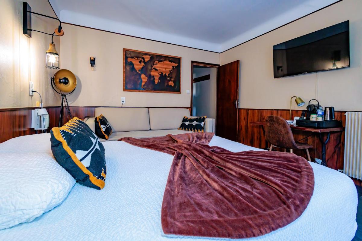 une chambre avec un lit avec une couverture dessus dans l'établissement Logis Central Hôtel - Restaurant & Spa, à Bort-les-Orgues