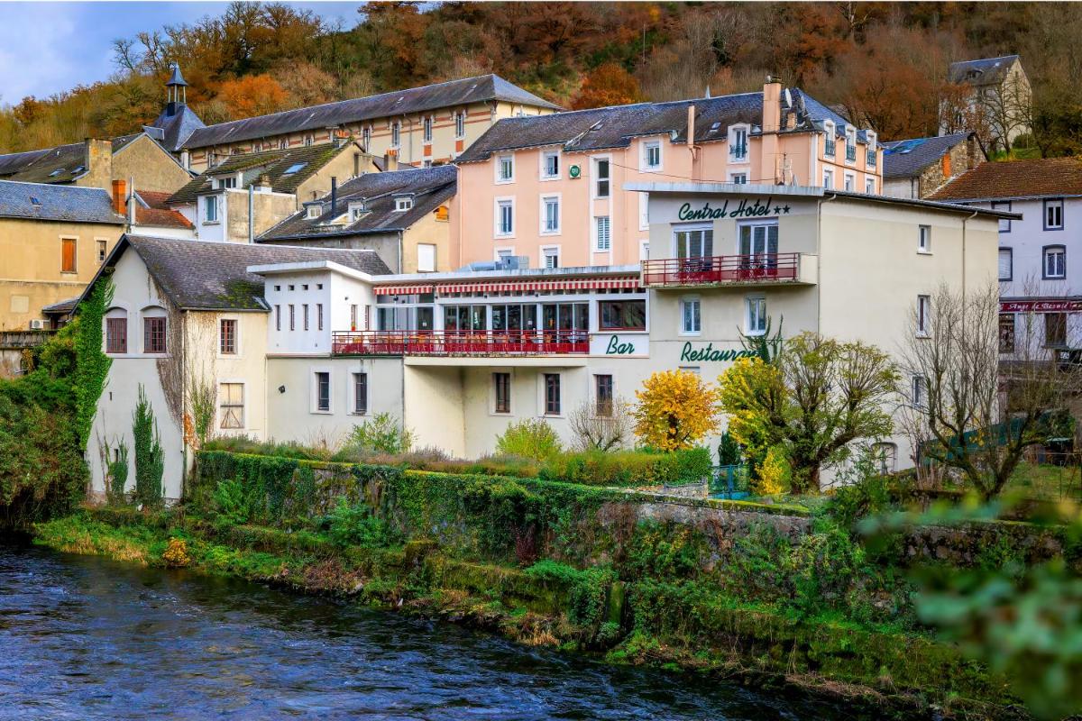 un groupe de bâtiments à côté d'une rivière dans l'établissement Logis Central Hôtel - Restaurant & Spa, à Bort-les-Orgues