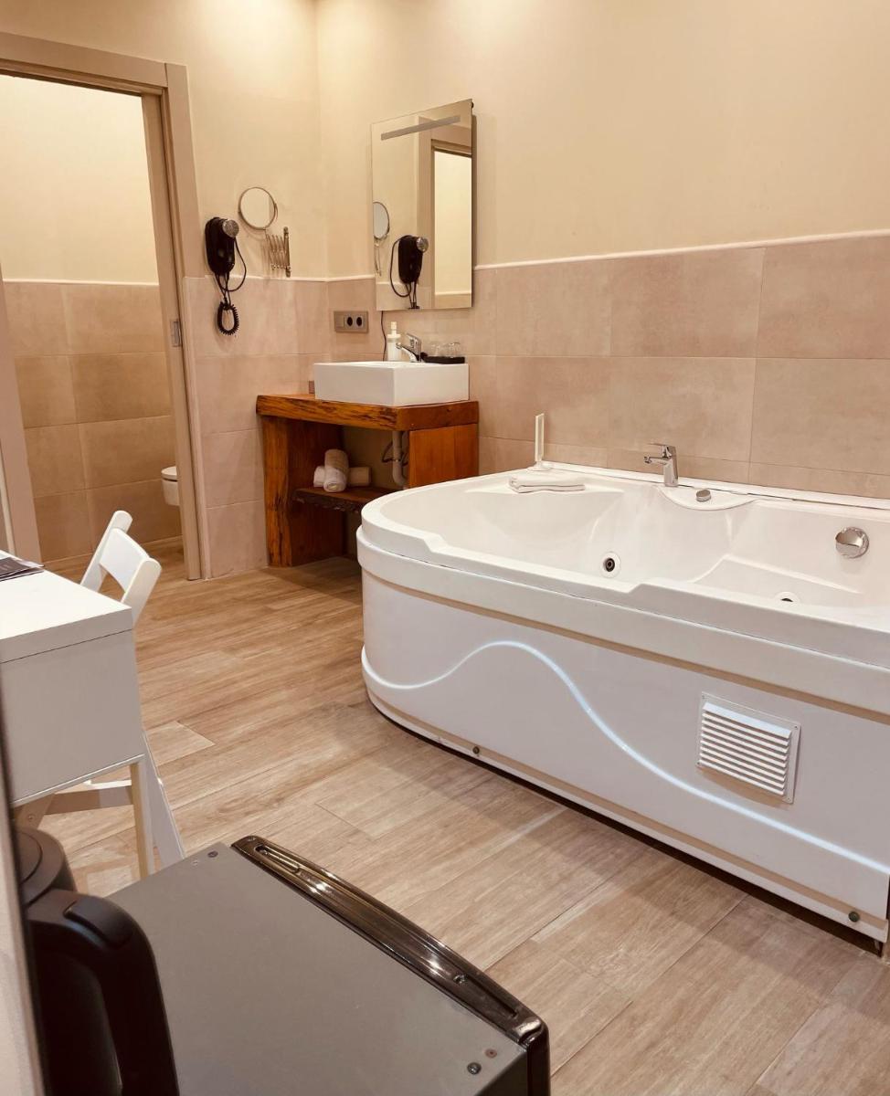 Un baño con bañera blanca y lavabo. en Nastasi Hotel & Spa, en Lleida