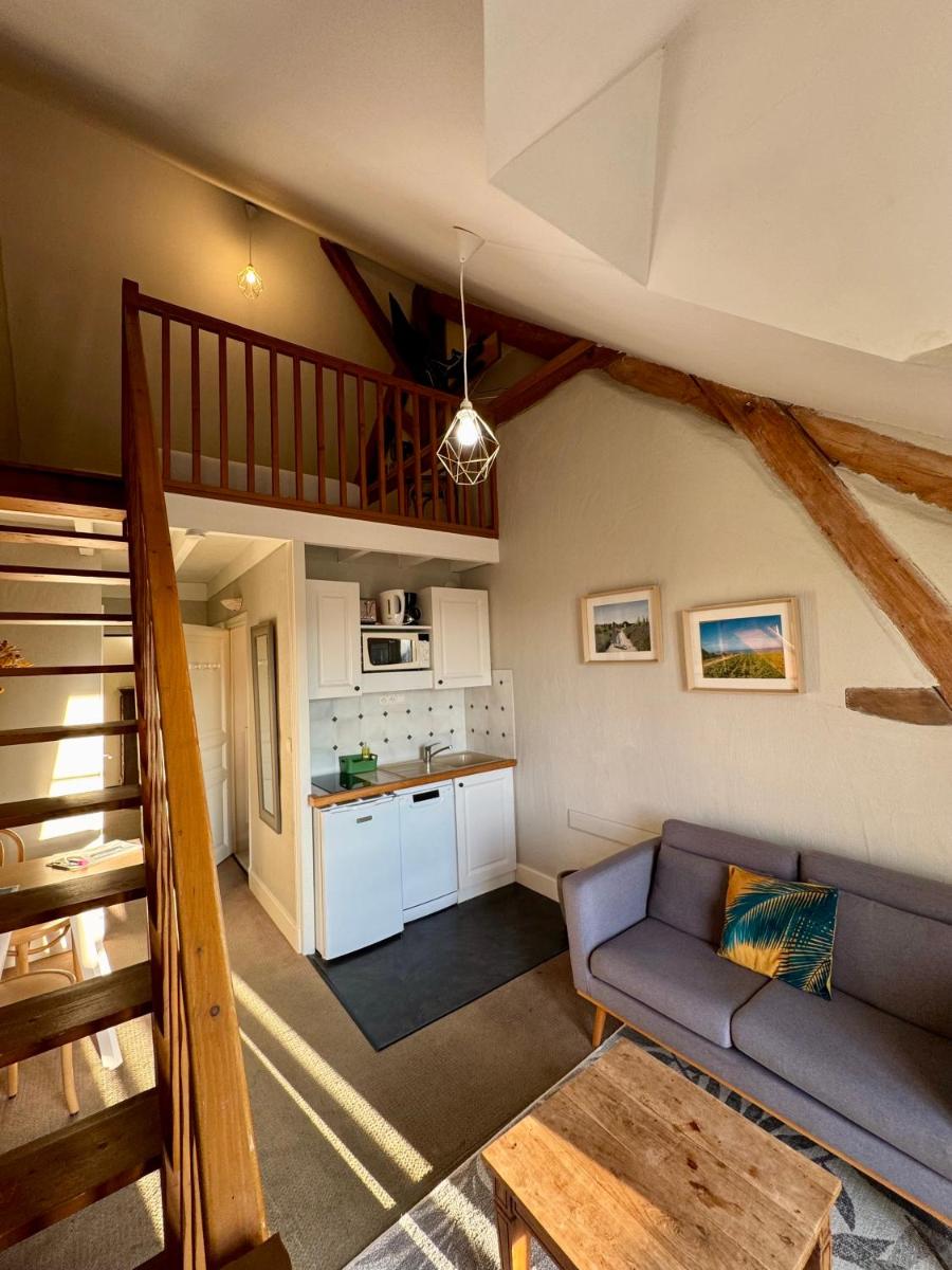 un salon avec un canapé et une cuisine dans l'établissement Eco-Domaine La Fontaine - RESIDENCE-SPA - Plage de la Fontaine aux Bretons, à Pornic