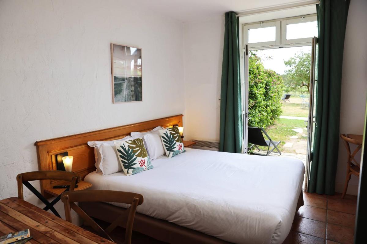 un lit dans une chambre avec une fenêtre dans l'établissement Eco-Domaine La Fontaine - RESIDENCE-SPA - Plage de la Fontaine aux Bretons, à Pornic 101 autres photos