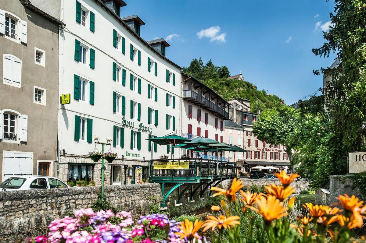un groupe de bâtiments et de fleurs dans une ville dans l'établissement Logis Hotel Restaurant Family & Spa, à Meyrueis
