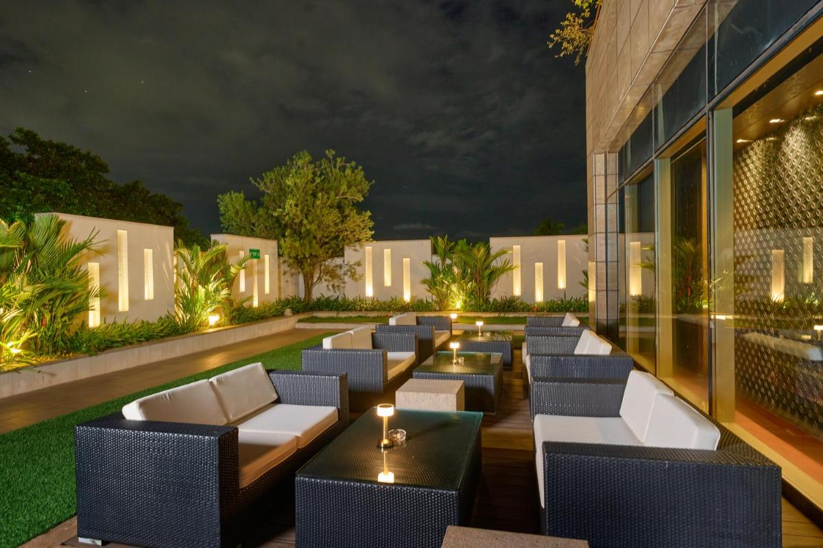 a bar with couches and tables in front of a building at Crowne Plaza Kochi by IHG in Cochin