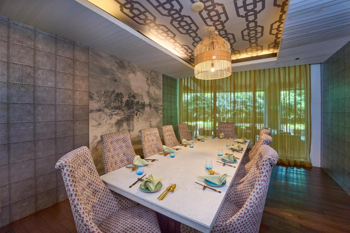 a dining room with a long table and chairs at Crowne Plaza Kochi by IHG in Cochin