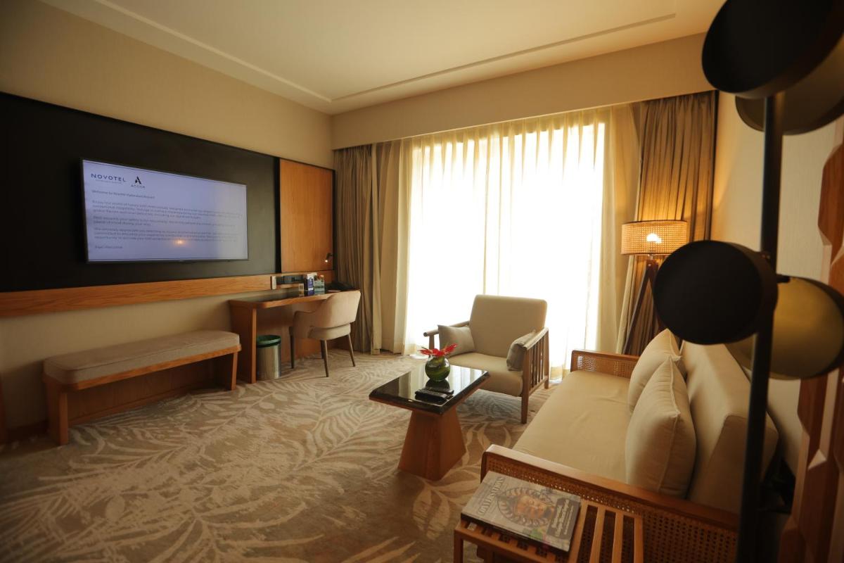 a hotel room with a bed and a desk at Novotel Hyderabad Airport in Hyderabad