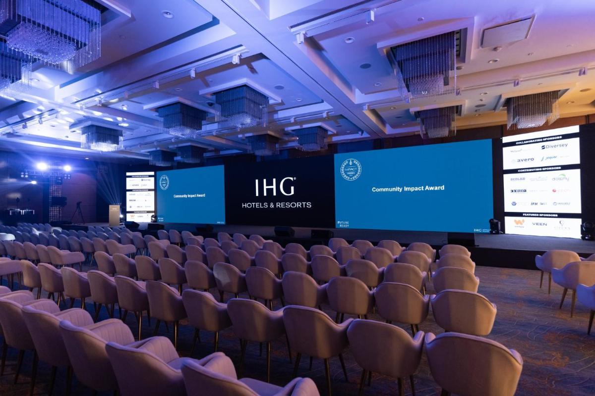 a lecture hall with rows of chairs and screens at Crowne Plaza Today Gurugram by IHG in Gurgaon