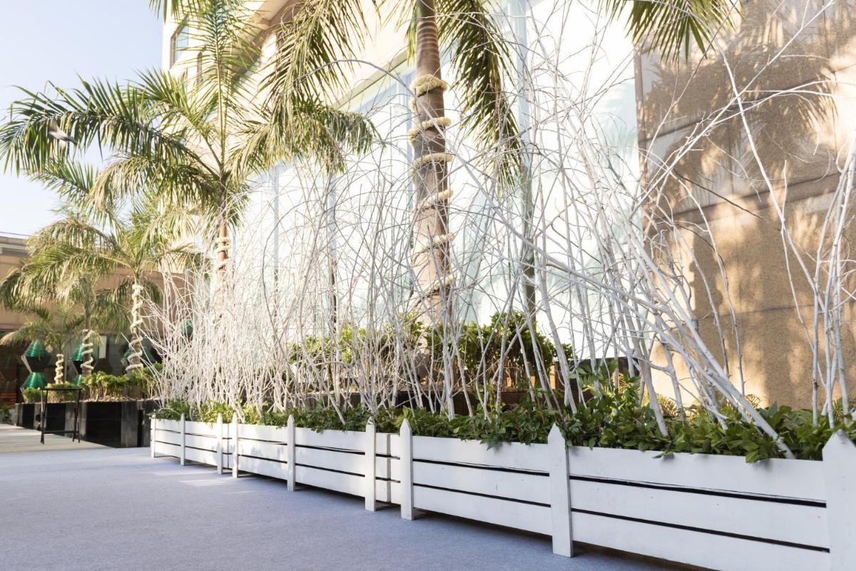 a row of palm trees in front of a building at Crowne Plaza Today Gurugram by IHG in Gurgaon