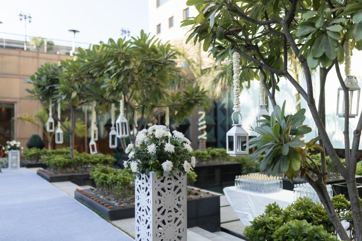 a garden with trees and flowers in a building at Crowne Plaza Today Gurugram by IHG in Gurgaon