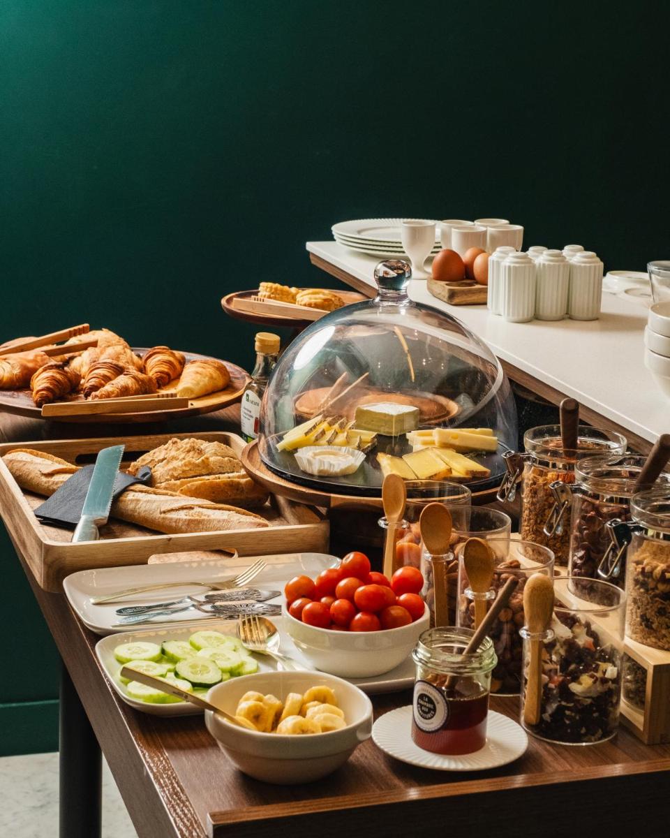 un buffet avec des assiettes de nourriture sur une table dans l'établissement Hôtel Artemisia Montmartre, à Paris 76 autres photos